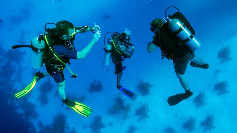 group of scuba divers performing safety stop while diving underwater
