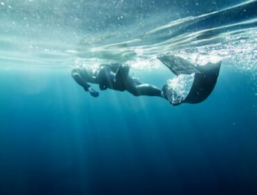 spearfisher underwater with spearfishing fins