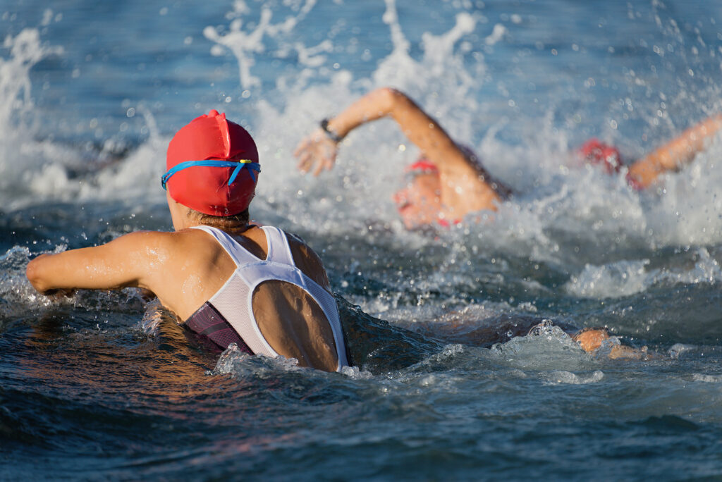 Group people in wetsuit swimming at triathlon