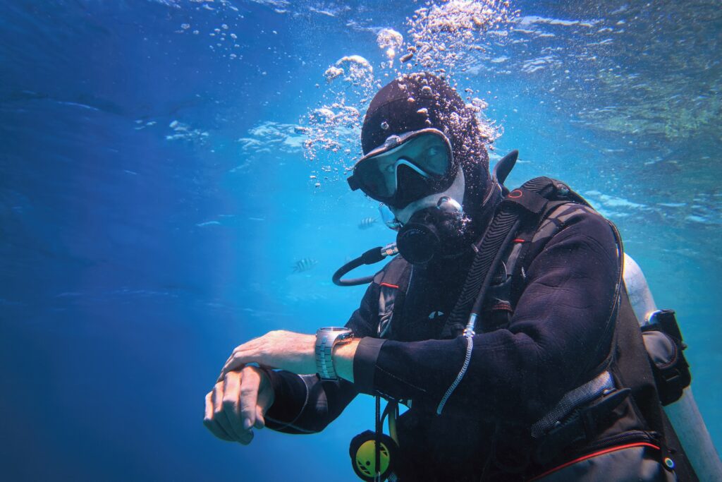 Fully equipped man scuba diver using the 120 rule underwater in the blue water