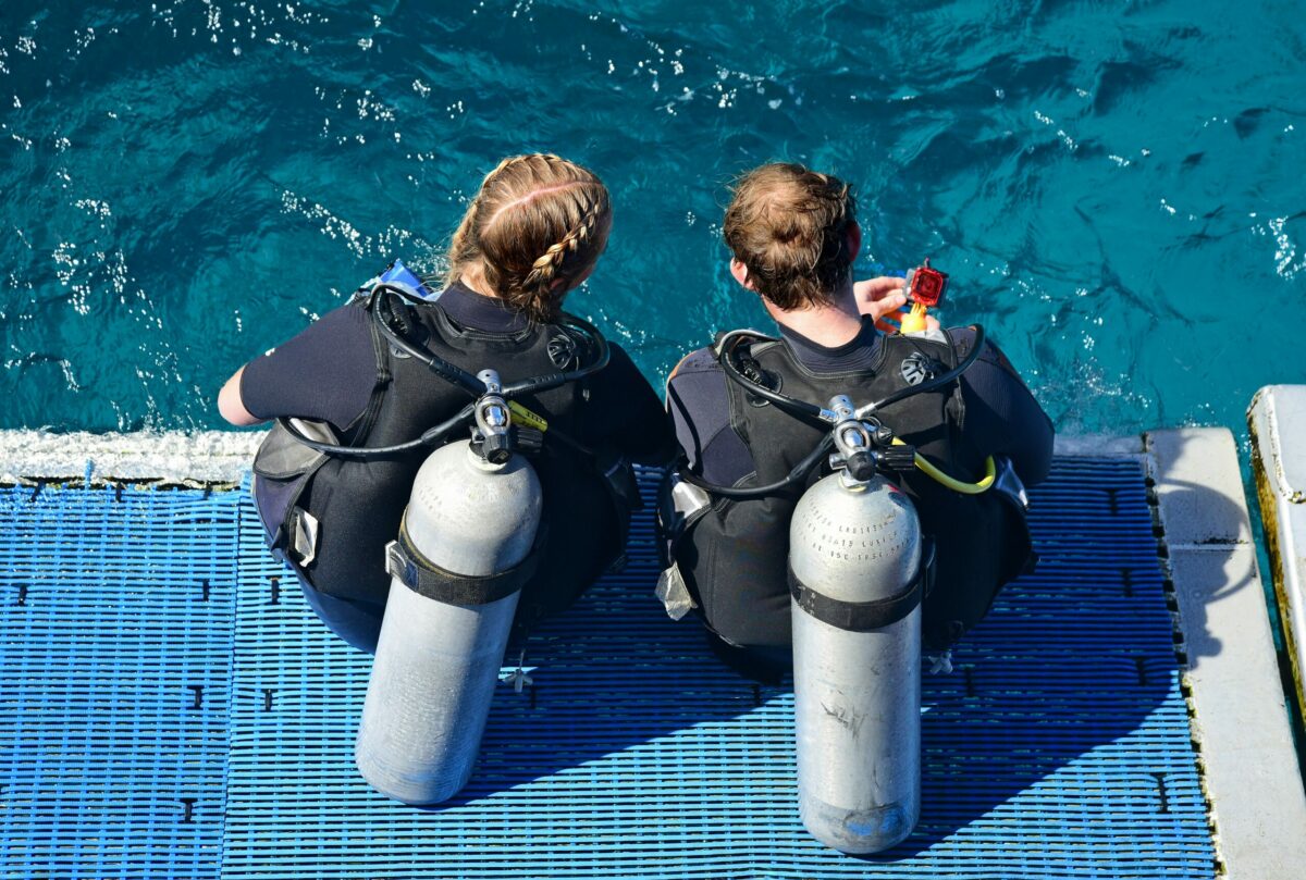 Two scuba divers talking about the 120 rule before a dive