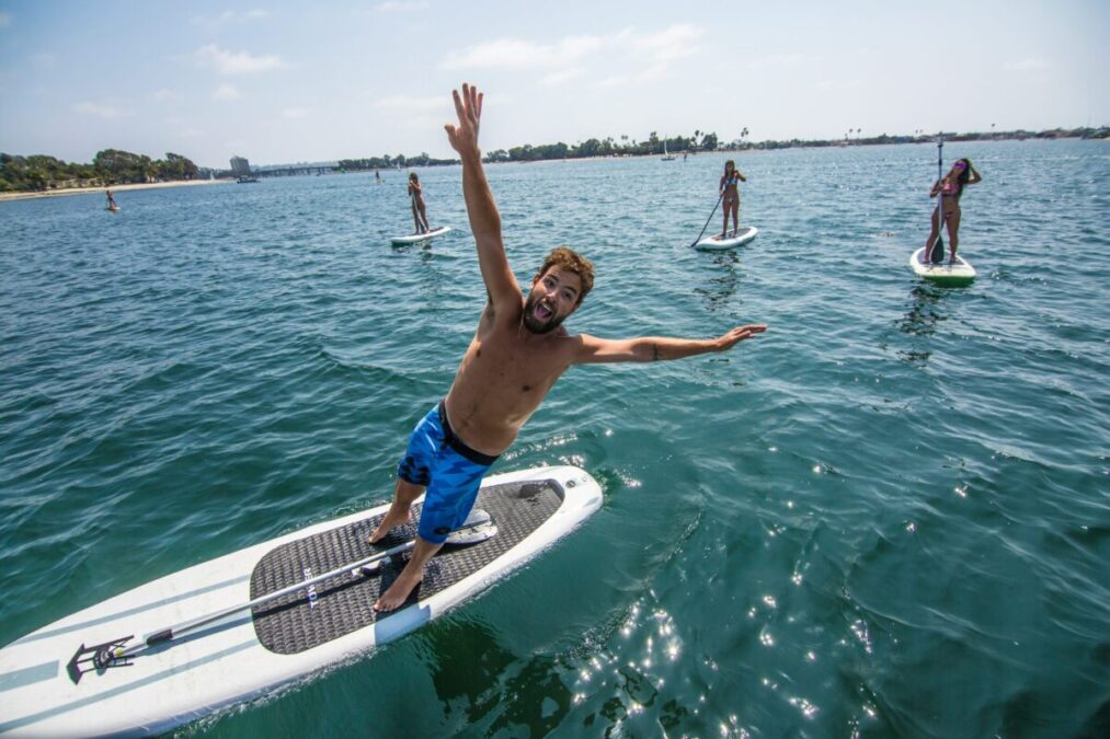 a man standing on a paddleboard as an example of SUP yoga