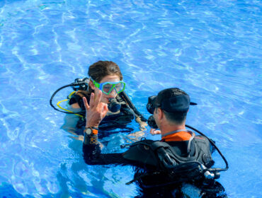 kid taking a scuba diving lesson in swimming pool at a kid-friendly diving location