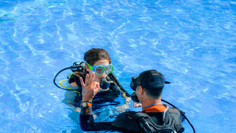 kid taking a scuba diving lesson in swimming pool at a kid-friendly diving location