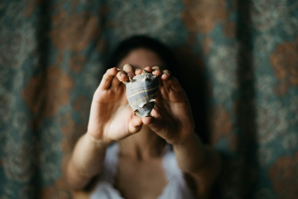 a girl holding a seashell