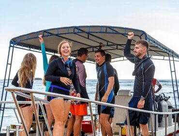 group of divers from the diving center on a boat swim to the dive site, young boys and girls, an adult instructor, Asia Sri Lanka.