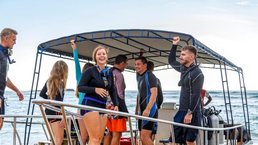 group of divers from the diving center on a boat swim to the dive site, young boys and girls, an adult instructor, Asia Sri Lanka.