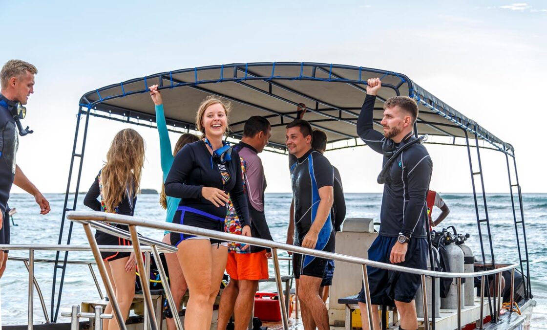group of divers from the diving center on a boat swim to the dive site, young boys and girls, an adult instructor, Asia Sri Lanka.