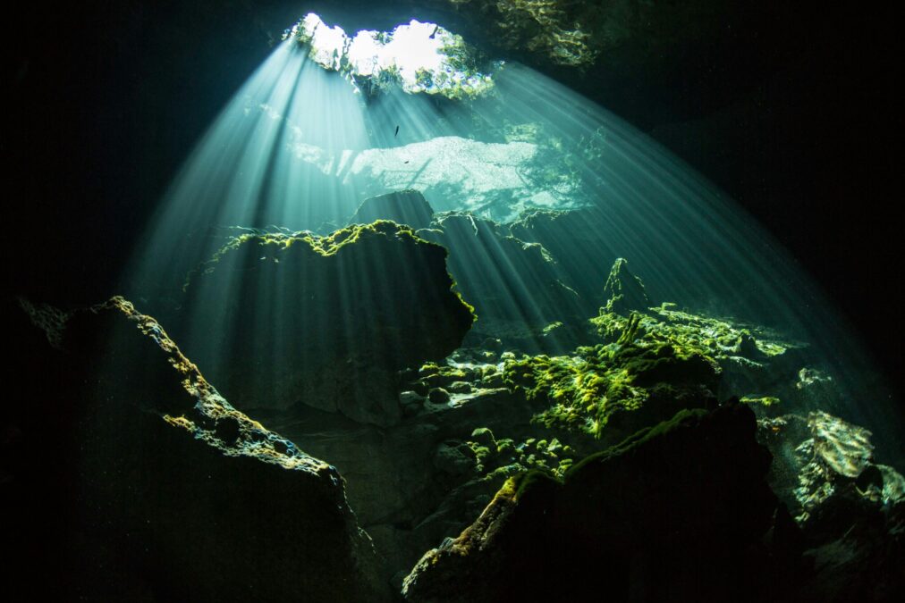 light peeking in from an opening in an underwater cave