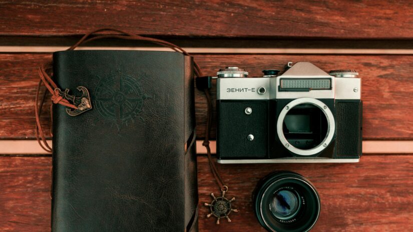 a picture of a scuba diving logbook beside a camera and camera lens