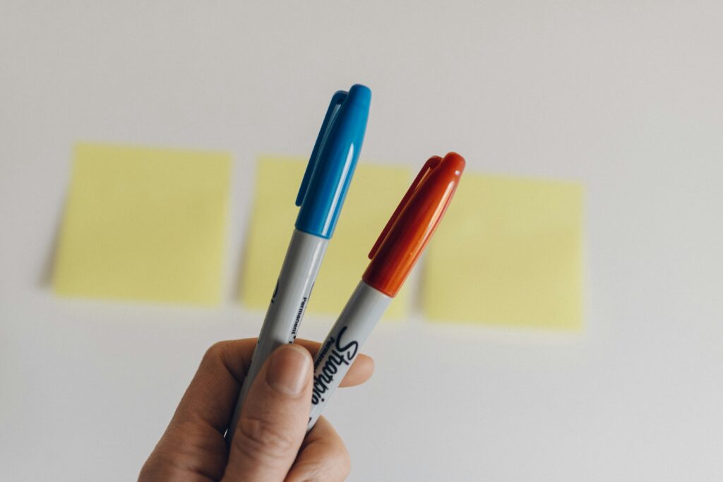 Person holding two permanent markers