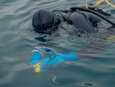 diver holding gear underwater