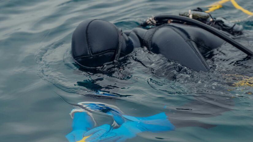 diver holding gear underwater