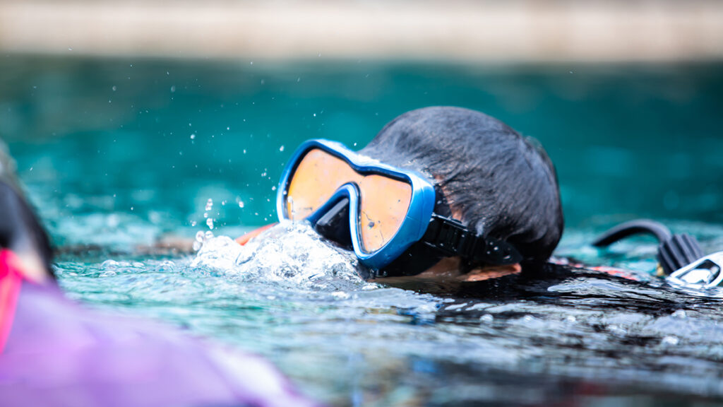 Selective focus to scuba diver training in the pool. A diver pra