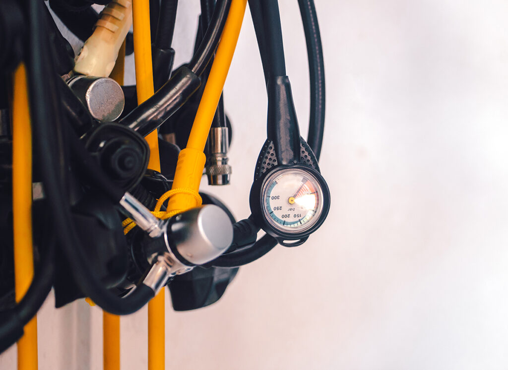 Equipment for diving, scuba diving underwater. Regulators, pressure gauges in a tank, cylinder, tools with a dial close-up in a dive center.