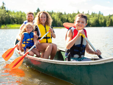 A Family in a Canoe on a Lake with life jackets having fun
