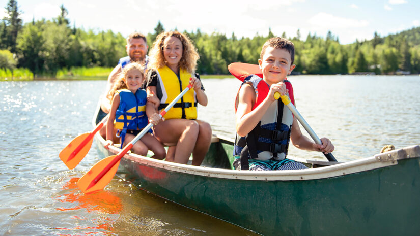 A Family in a Canoe on a Lake with life jackets having fun