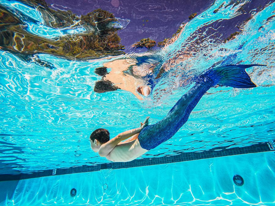 little boy in monofin learns mermaid freediving in a pool