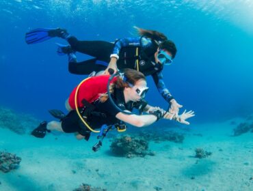 Shereen Ramadan guiding a student underwater while diving