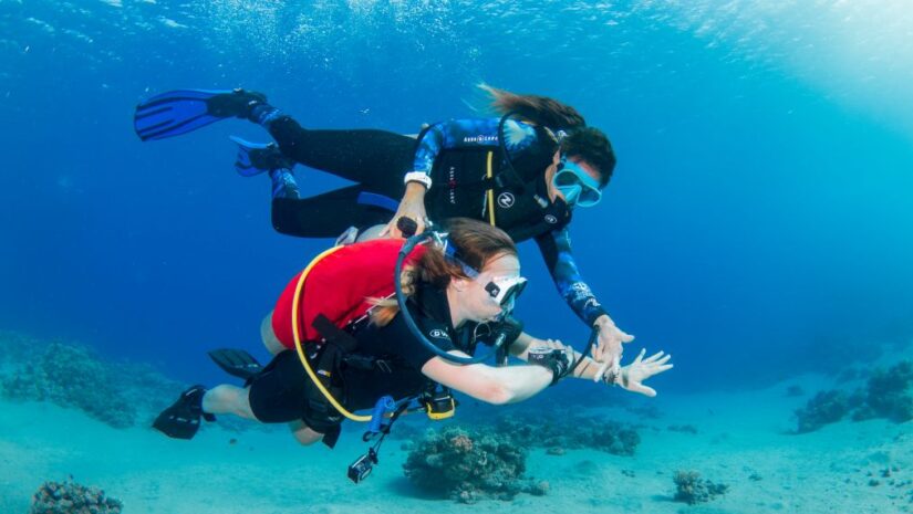 Shereen Ramadan guiding a student underwater while diving