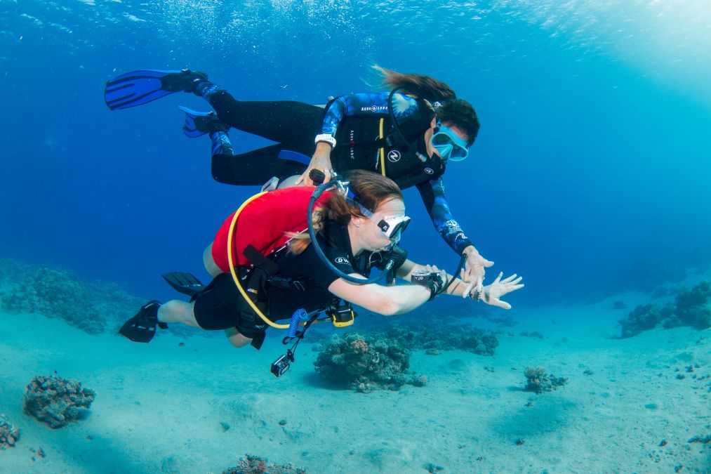 Shereen Ramadan guiding a student underwater while diving