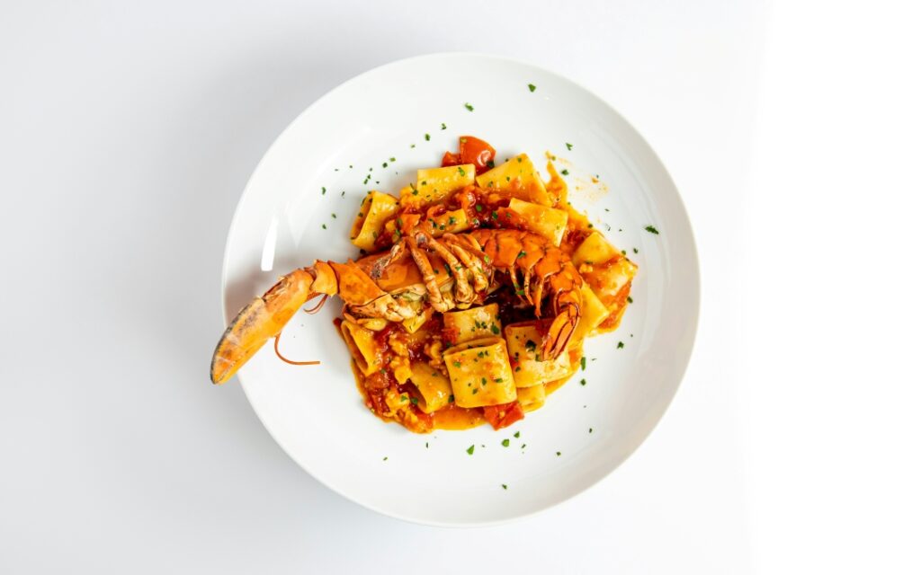 a white plate topped with pasta and shrimp 
