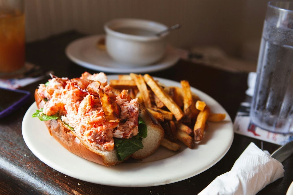 a plate of food with fries and lobster with brioche