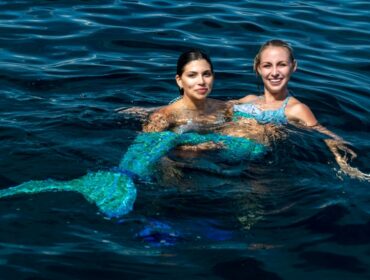 two mermaid divers in the ocean