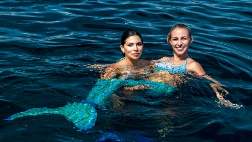 two mermaid divers in the ocean