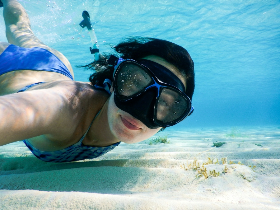 woman poses for camera with snorkel mask