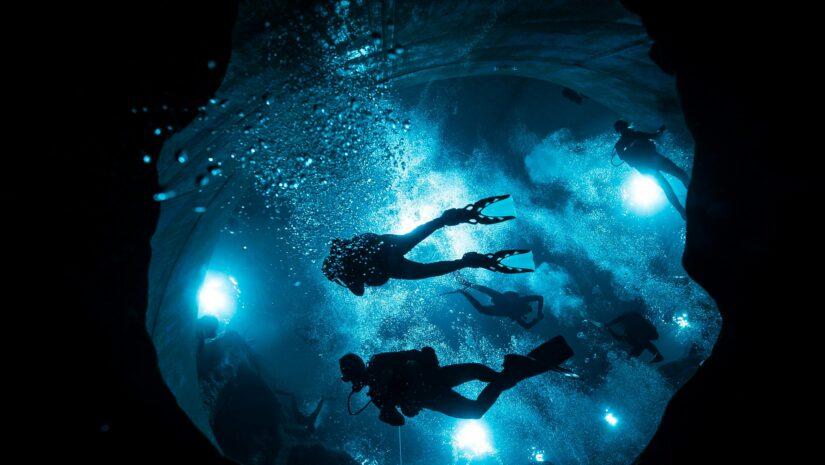 a group night diving holding their flashlights