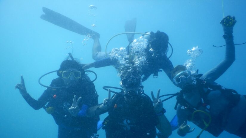 scuba diving friends posing happily for the camera
