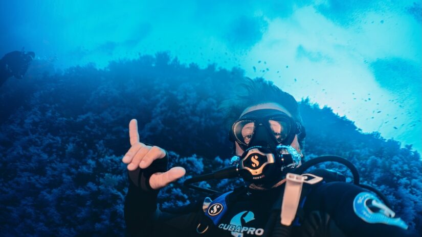 scuba diver posing for a picture with complete scuba equipment