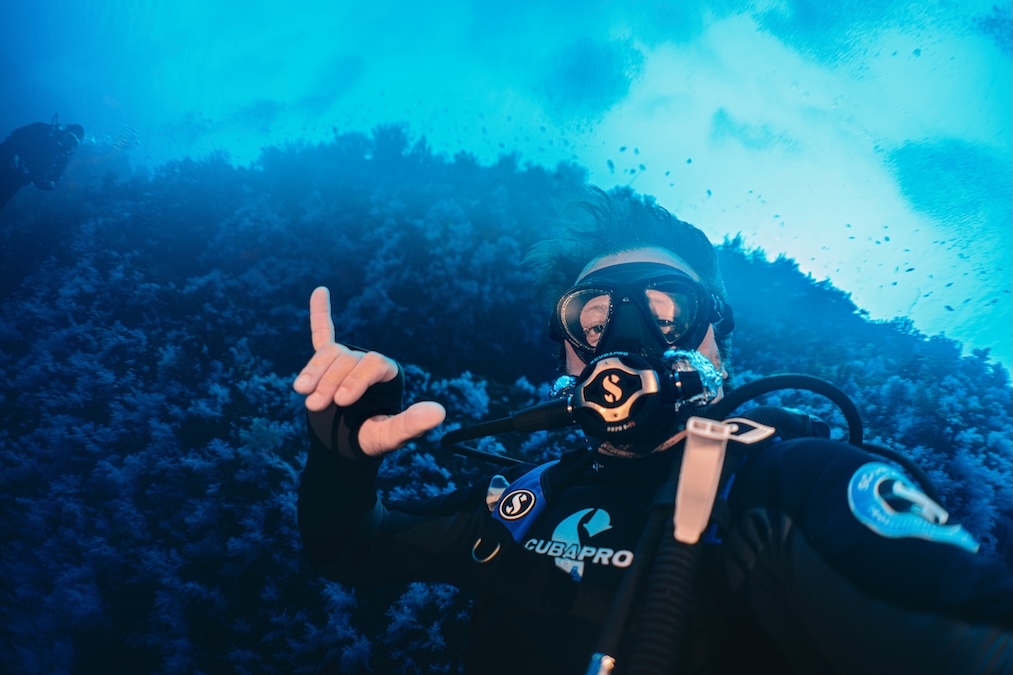 scuba diver posing for a picture with complete scuba equipment