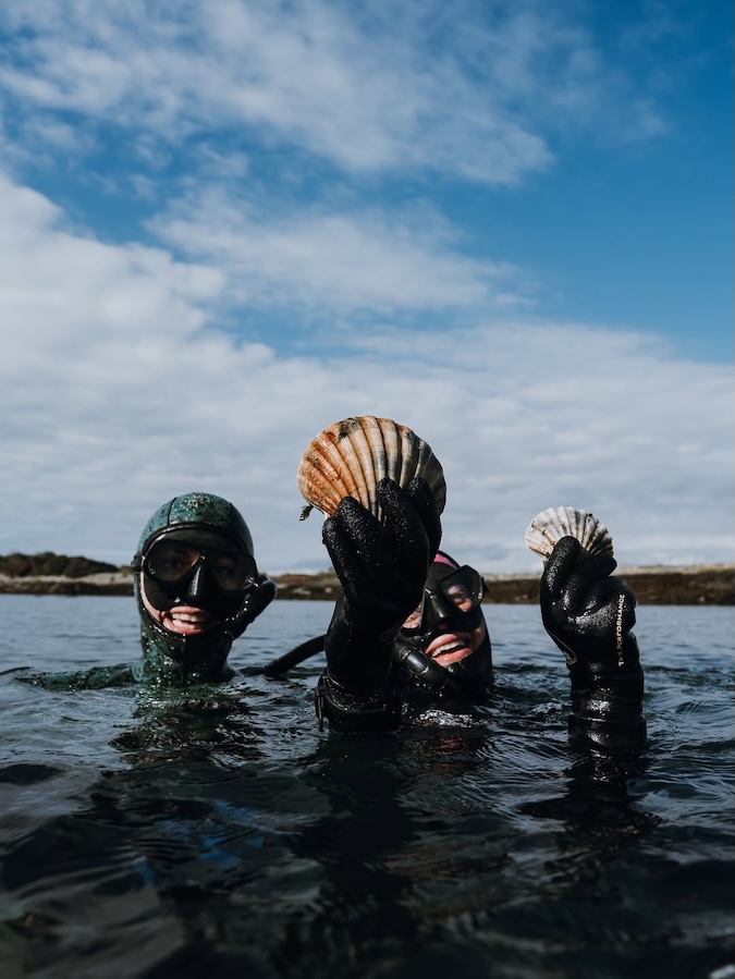 freedivers holding up seashells