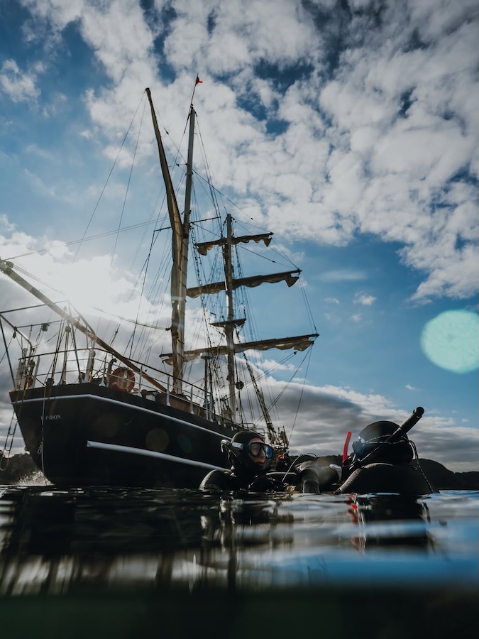 a ship contrasted by a bright cloudy blue sky
