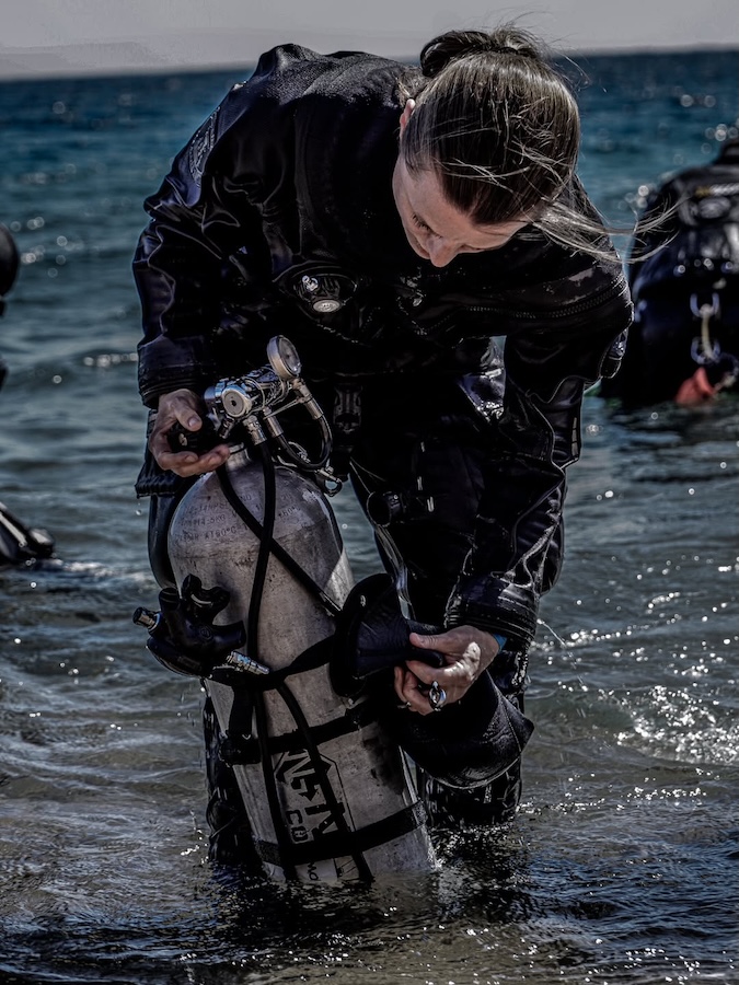 diver adjusts her scuba diving gear