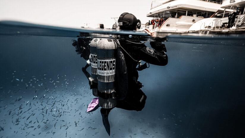 scuba diver treading water looking above the surface