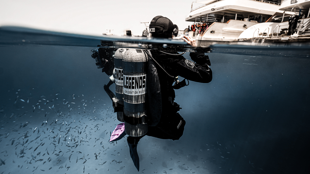 scuba diver treading water looking above the surface